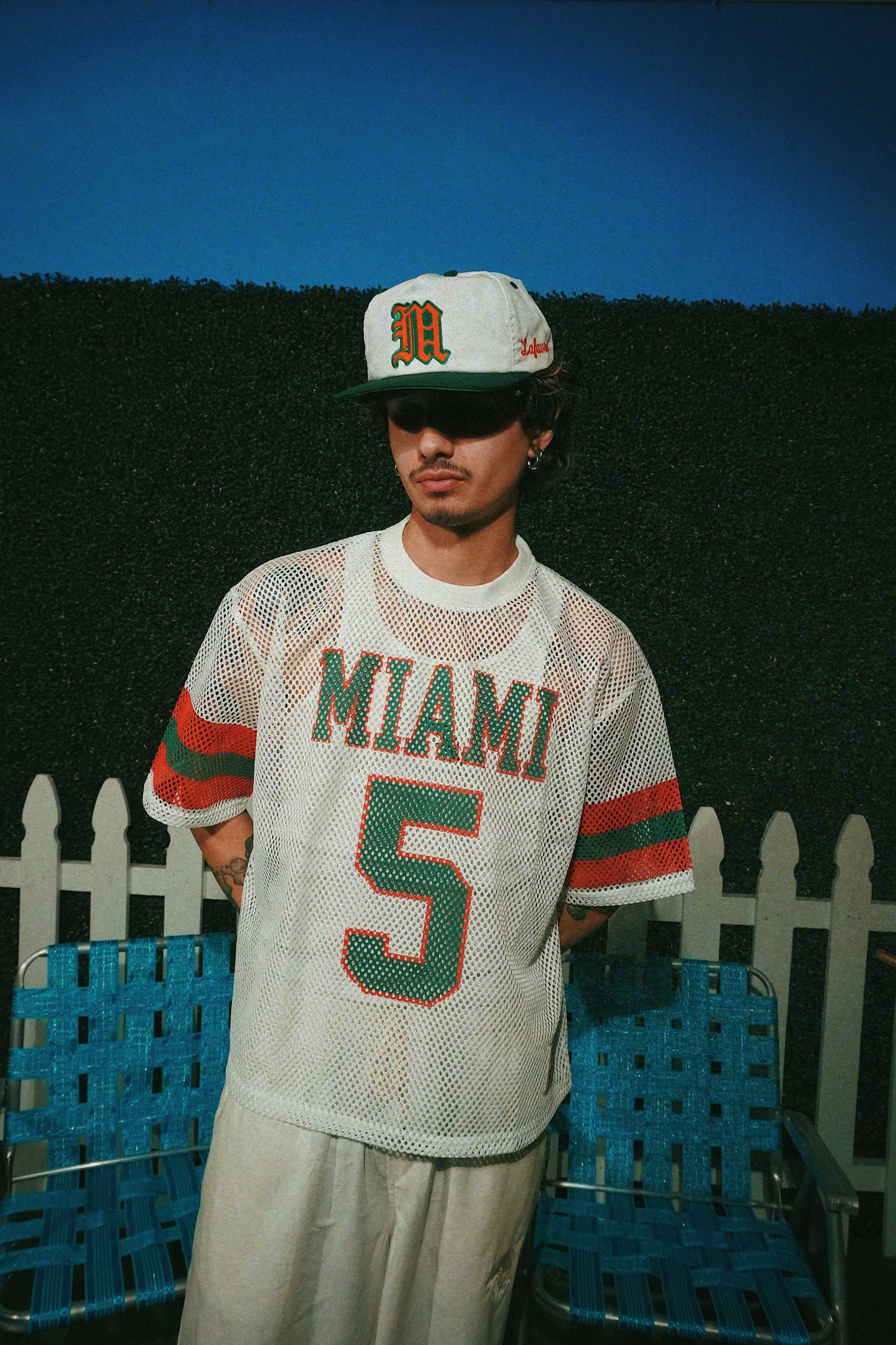 Person wearing a 'Miami' jersey with number 5 and a cap, standing outdoors.
