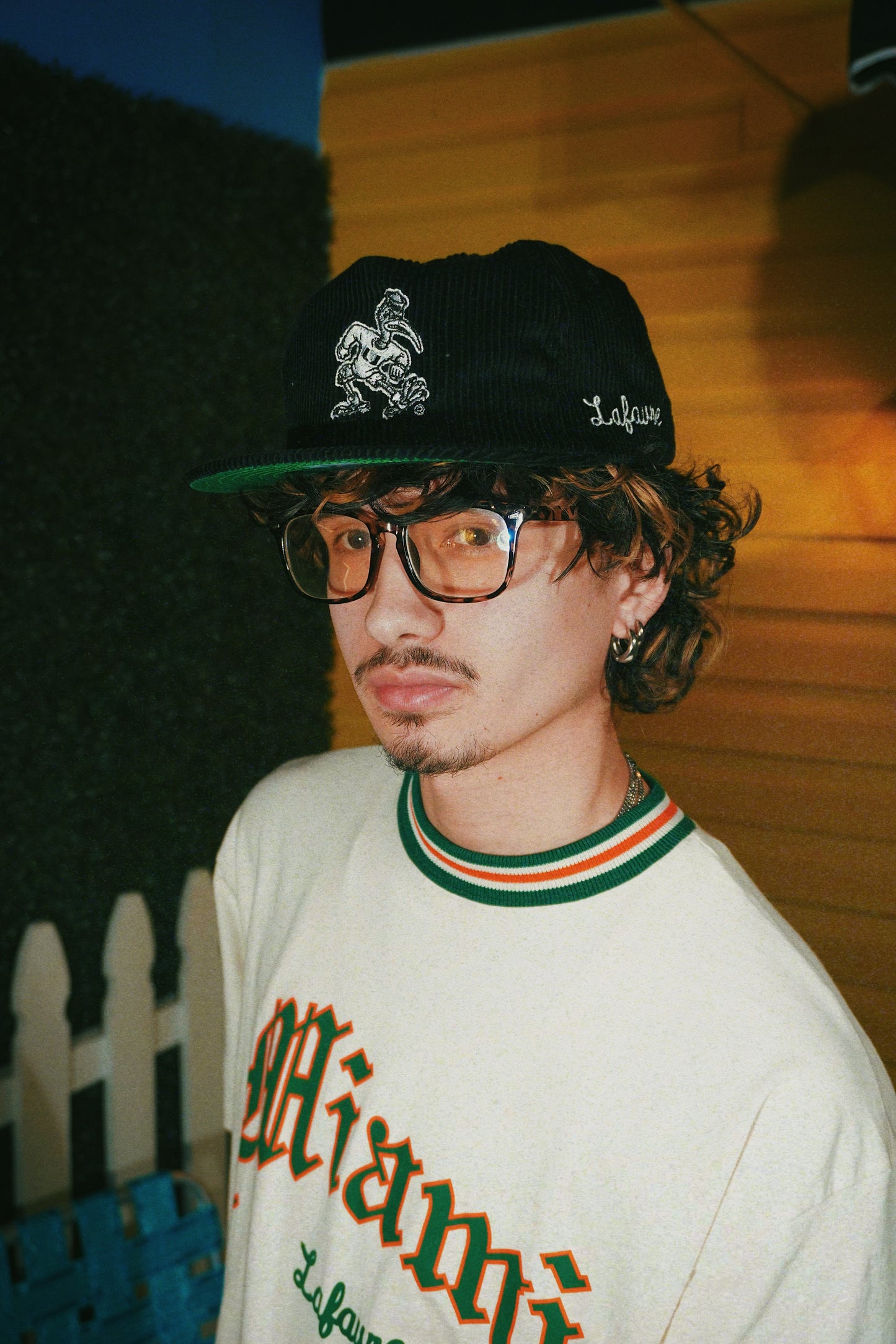Person wearing a cap and glasses with a blurred background