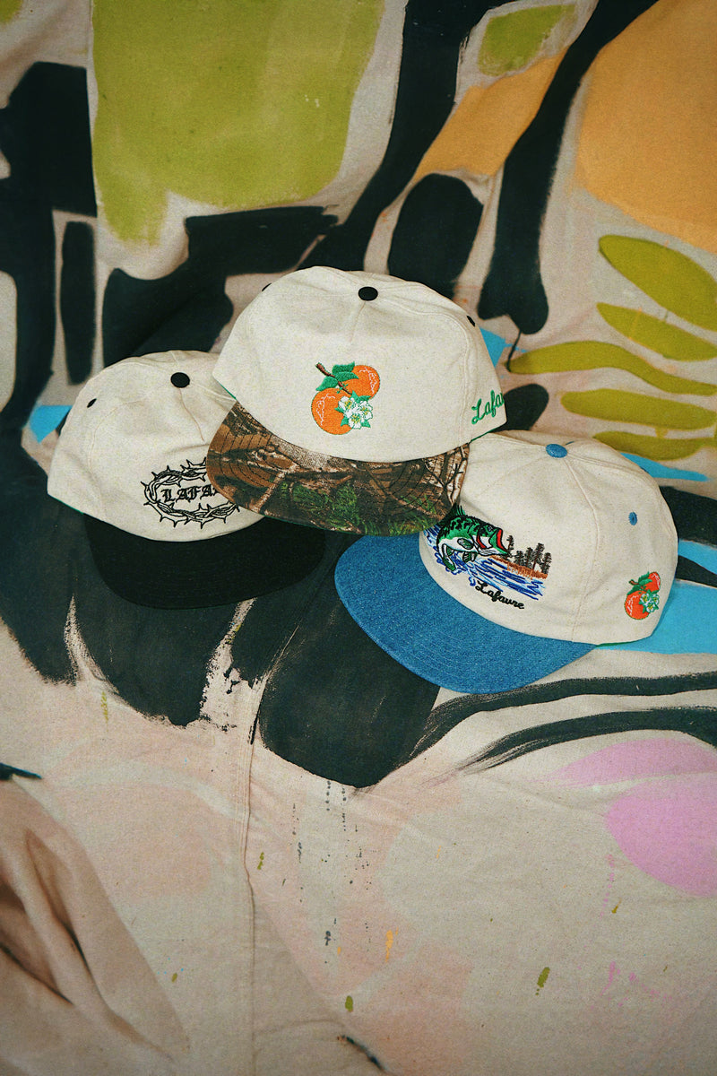 Three baseball caps with different designs on a colorful, abstract background