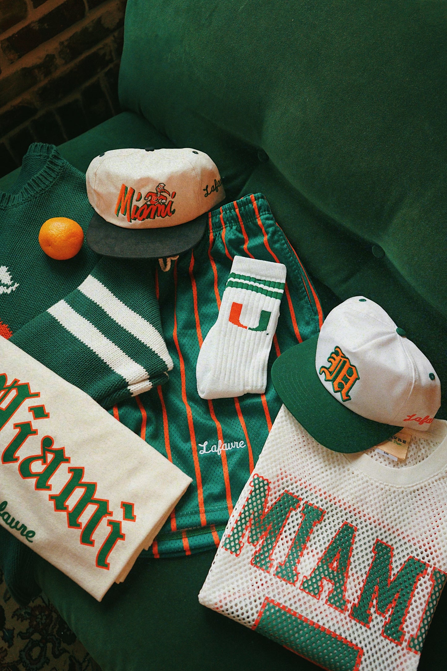 Collection of Miami-themed merchandise including hats, socks, and towels on a green surface.