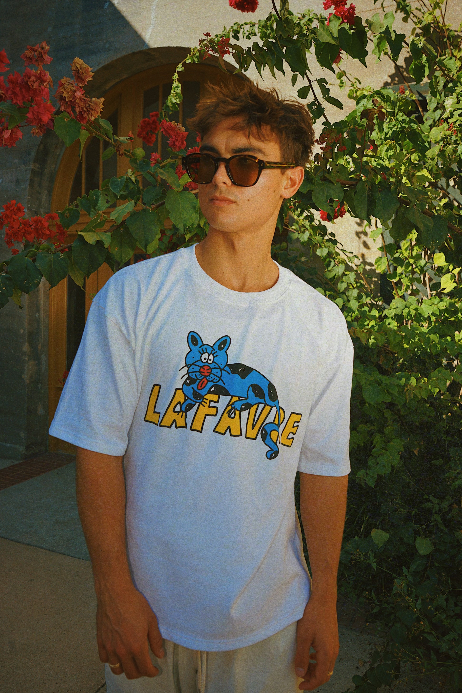 Person wearing a white t-shirt with a graphic design outdoors