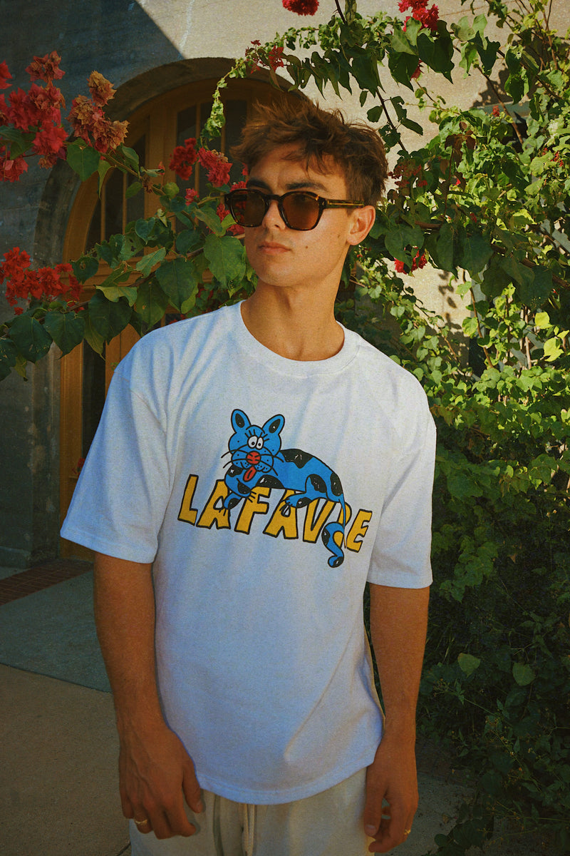 Person wearing a white t-shirt with a graphic design outdoors